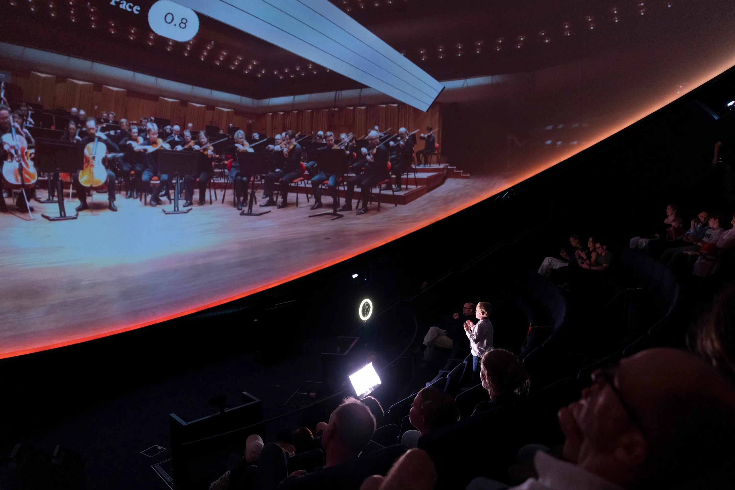 Wide view of the orchestra projection responding to a visitor's conducting